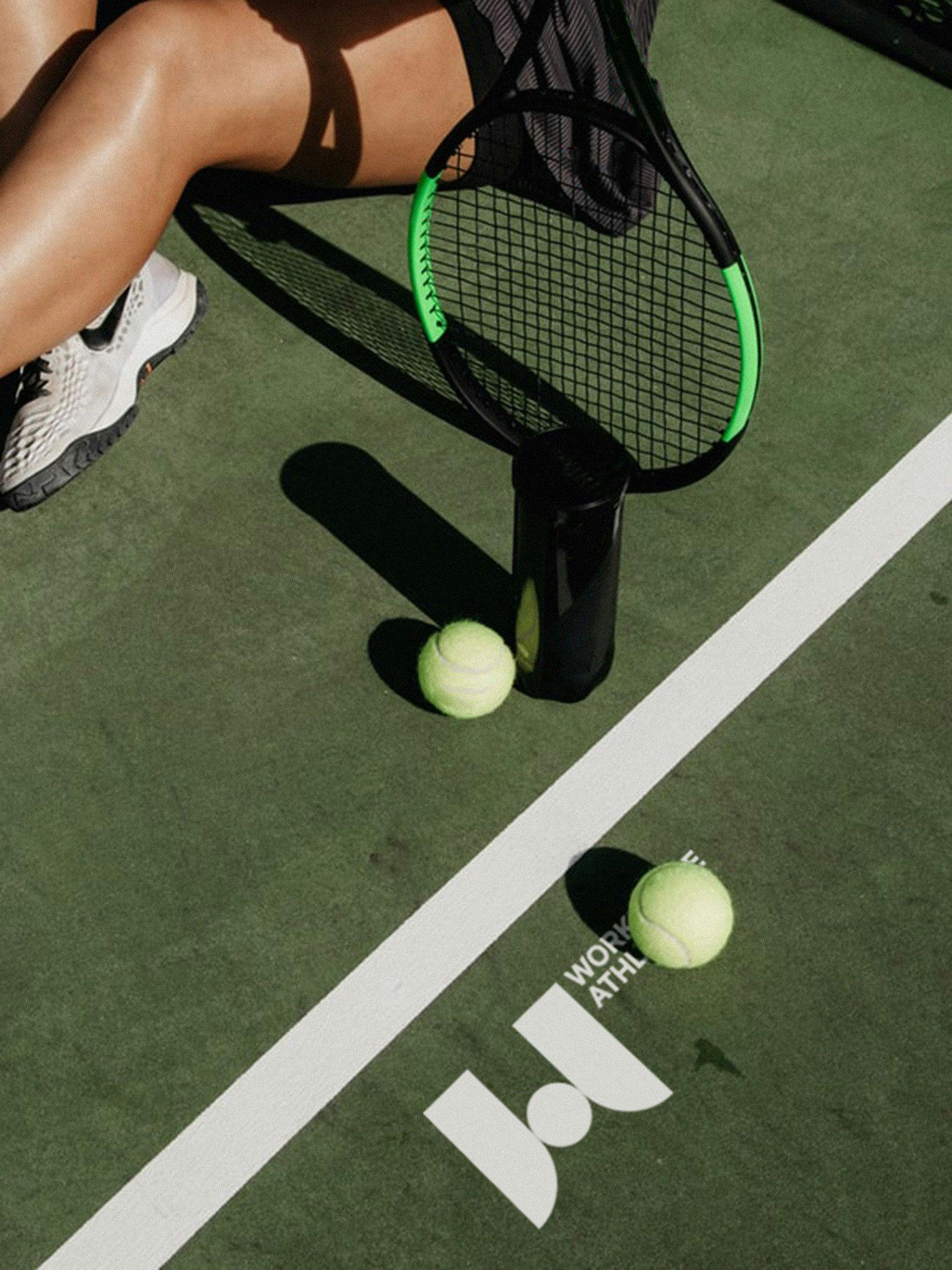A tennis player with racquets and tennis balls