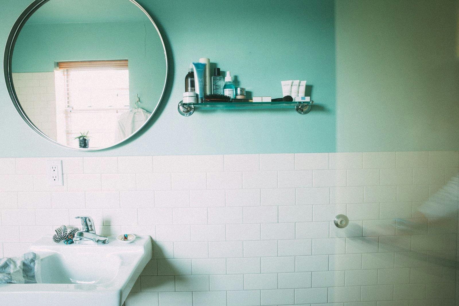 Bathroom sink with blue wall and round mirror