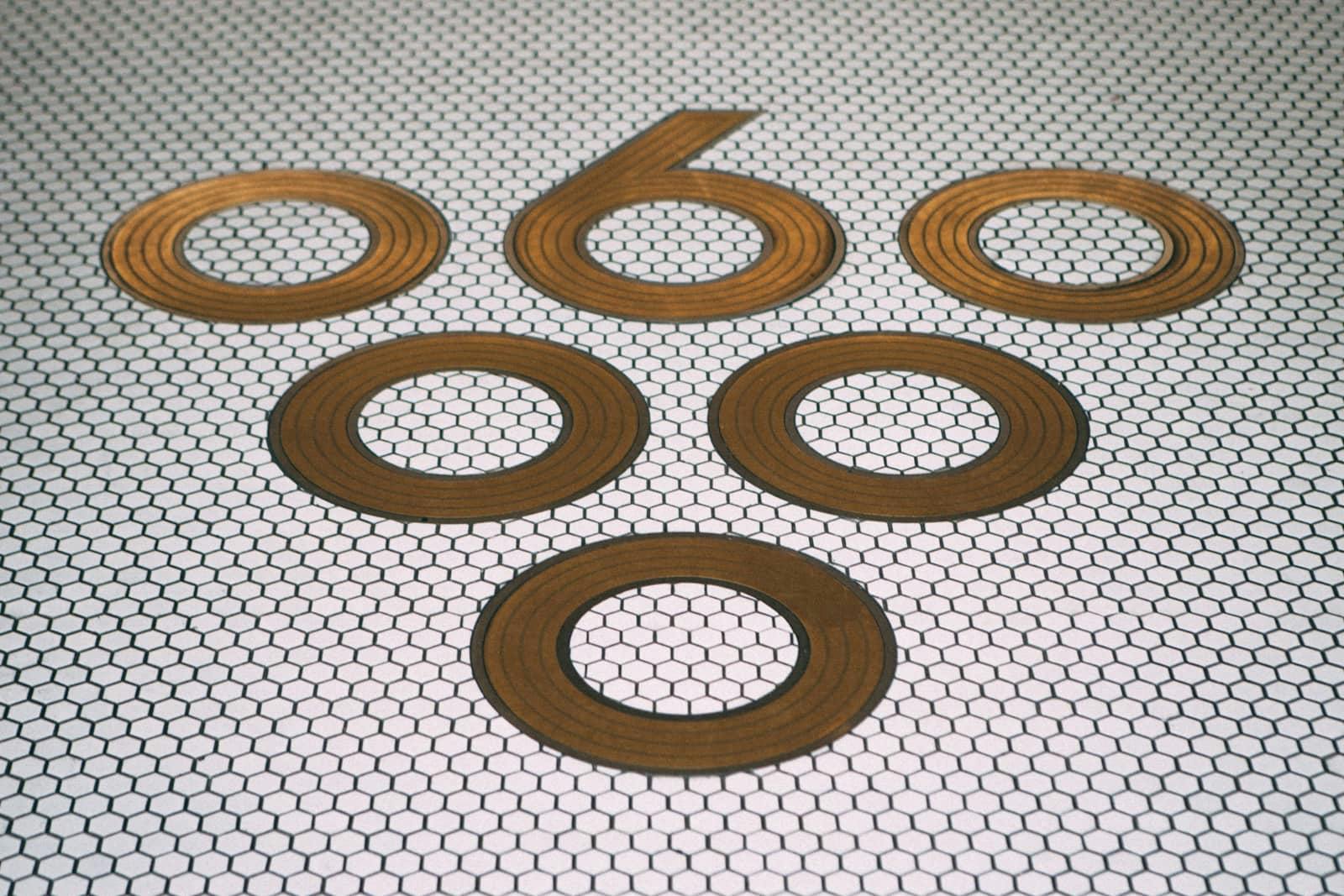Sixty Vines logo on a tiled floor