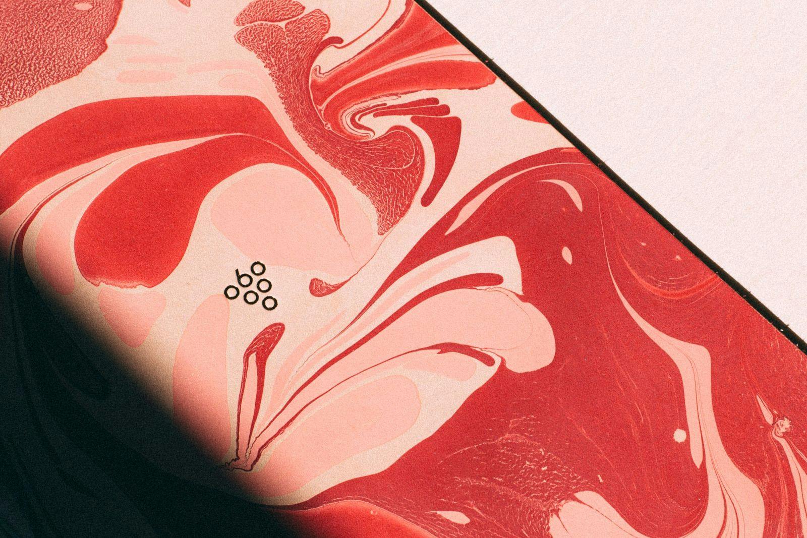 A close up of the Sixty Vines logo on a red marble background